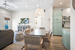 Enjoy meals at the large dining table surrounded by comfortable wicker chairs.
