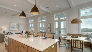 A spacious kitchen with a large island, wooden cabinets, and pendant lighting. - Keepin' It Reel 234 LAK (Port Aransas)