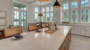 A spacious kitchen with a large island, white cabinetry, and pendant lighting. - Keepin' It Reel 234 LAK (Port Aransas)