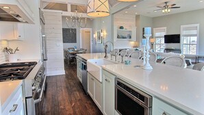 A modern kitchen with white cabinetry, stainless steel appliances, and a large island. - Oceanaire 196 RO (Port Aransas)
