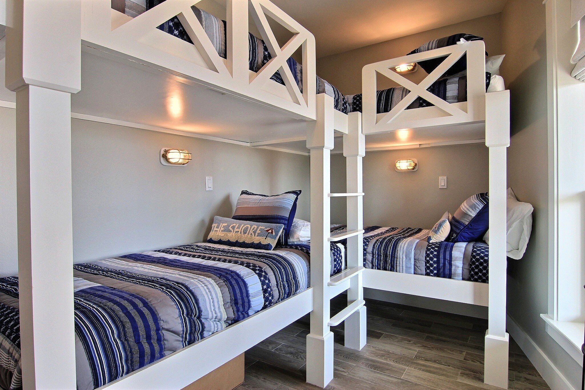 Une chambre avec un lit superposé, comportant deux lits, chacun doté d’une tête de lit au design géométrique unique.
