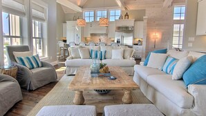 A spacious living room with a large sofa set, a wooden coffee table, and a kitchen in the background. - Oceanaire 196 RO (Port Aransas)