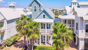 A coastal building with multiple balconies, a covered porch, and palm trees. - Casa al Mare 237 HI (Port Aransas)