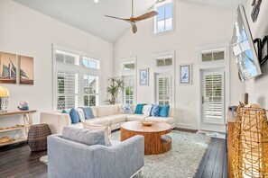 Relax in this stylish living room with a large L-shaped sofa, round coffee table, and wall-mounted TV.
