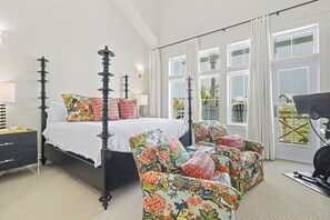 A bedroom with a four-poster bed, floral armchairs, a treadmill, and large windows with curtains. - Southern Seaside TC 9103 (Port Aransas)