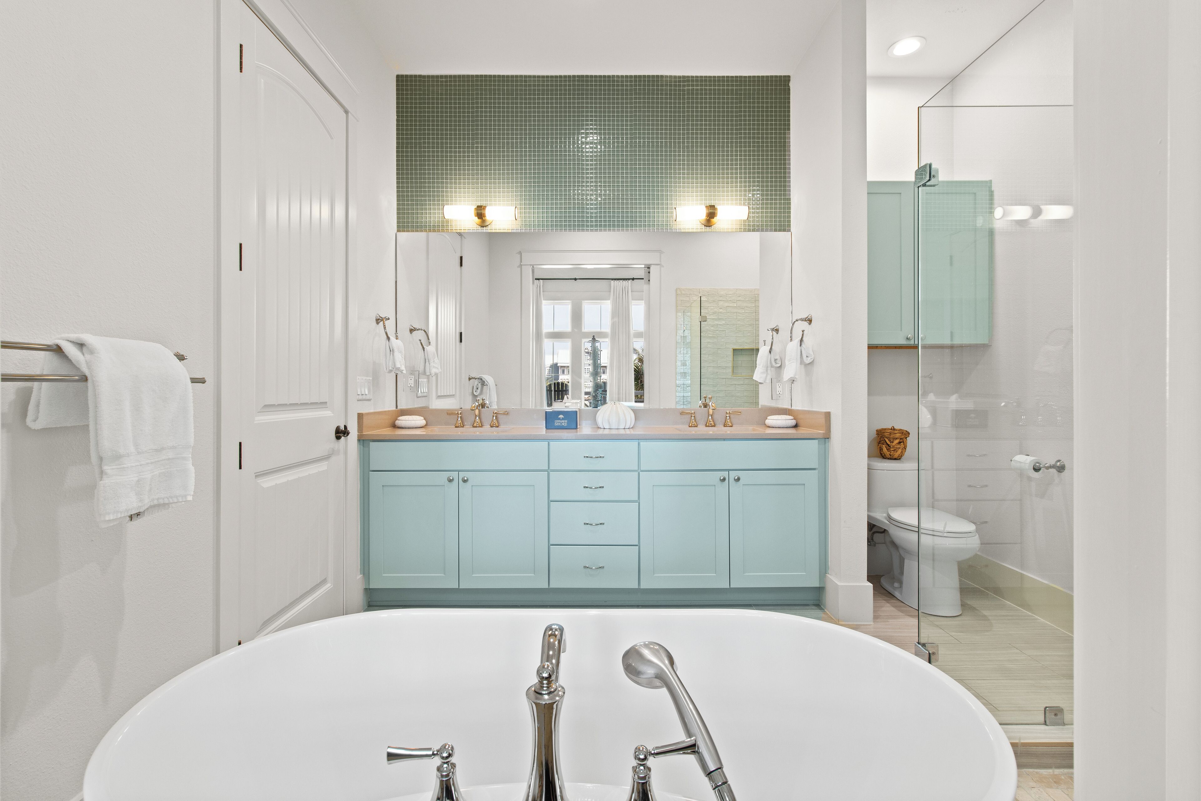 Une salle de bain moderne avec une baignoire sur pieds, un grand miroir et une douche séparée par des parois en verre.