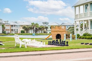 Guests can enjoy a leisurely game of chess on the lawn, surrounded by a serene body of water and lush greenery.