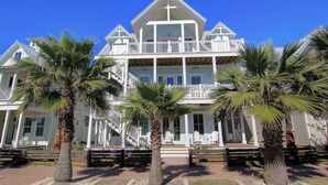 A large, multi-story building with a balcony and a porch. - Salt and Light 192 RO (Port Aransas)