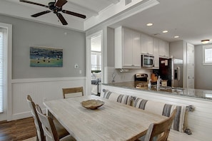 Enjoy meals in this well-appointed dining area with a table and chairs, surrounded by a kitchen with modern appliances and cabinetry.