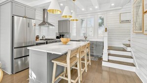 A modern kitchen with a large island, stainless steel appliances, and pendant lighting. - Sun Chaser Cottage 205 Fiv-d (Port Aransas)