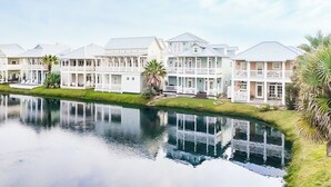 A waterfront property with multiple houses, a reflecting pool, and a grassy area. - The Veranda 141 BE (Port Aransas)