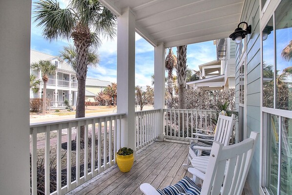 A covered porch with white railings, a wooden deck, and a yellow planter. - Sippin' on Sunshine 164 BE (Port Aransas)