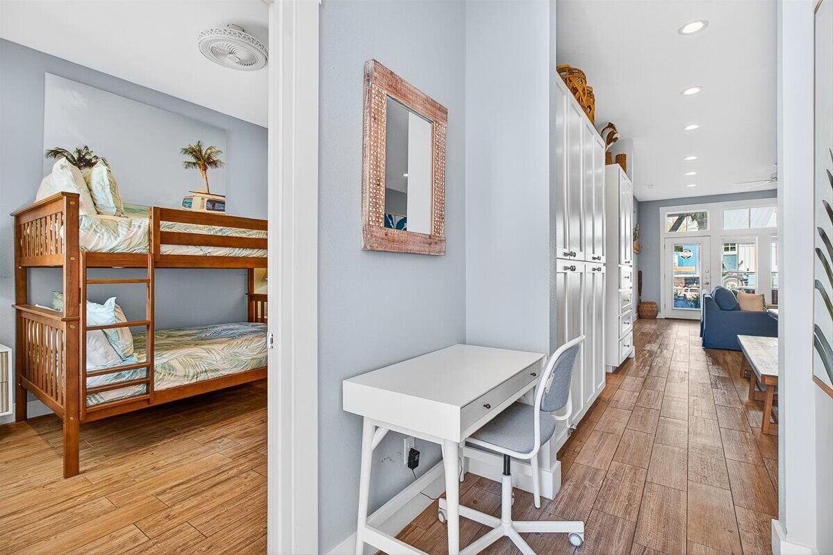 A room with a bunk bed, a desk, and a wardrobe.