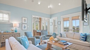 A spacious living room with a sofa, armchairs, a coffee table, and a dining area. - Shore House 183 BE (Port Aransas)
