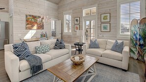 A spacious living room with two sofas, a coffee table, and artwork on the walls. - Sea Ya' Soon 130 ST (Port Aransas)