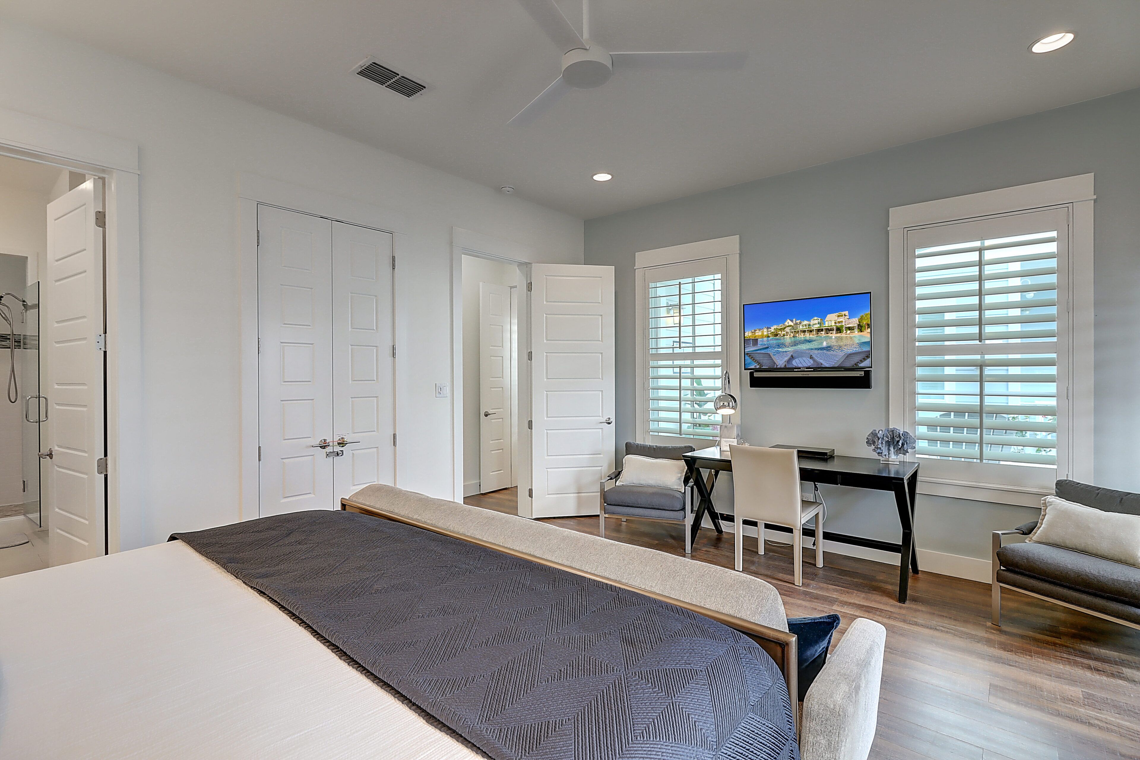 Une chambre à coucher avec un lit, un bureau, une chaise et un téléviseur.
