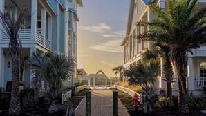 Un sendero lleva a una casa de playa con un porche y vista al océano.