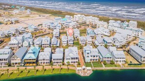 A coastal residential area with multiple houses, a dock, and a view of the ocean.