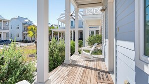 A covered porch with a rocking chair and a welcome mat.