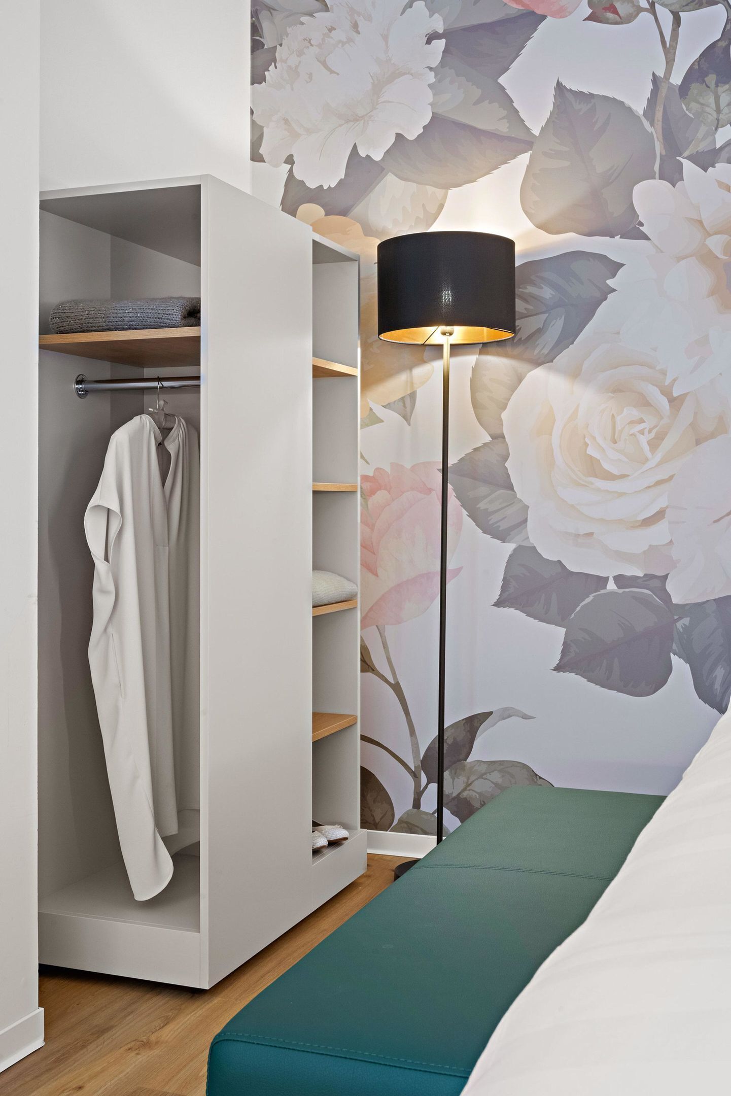 Une pièce comprenant une armoire, une lampe sur pied et un lit.