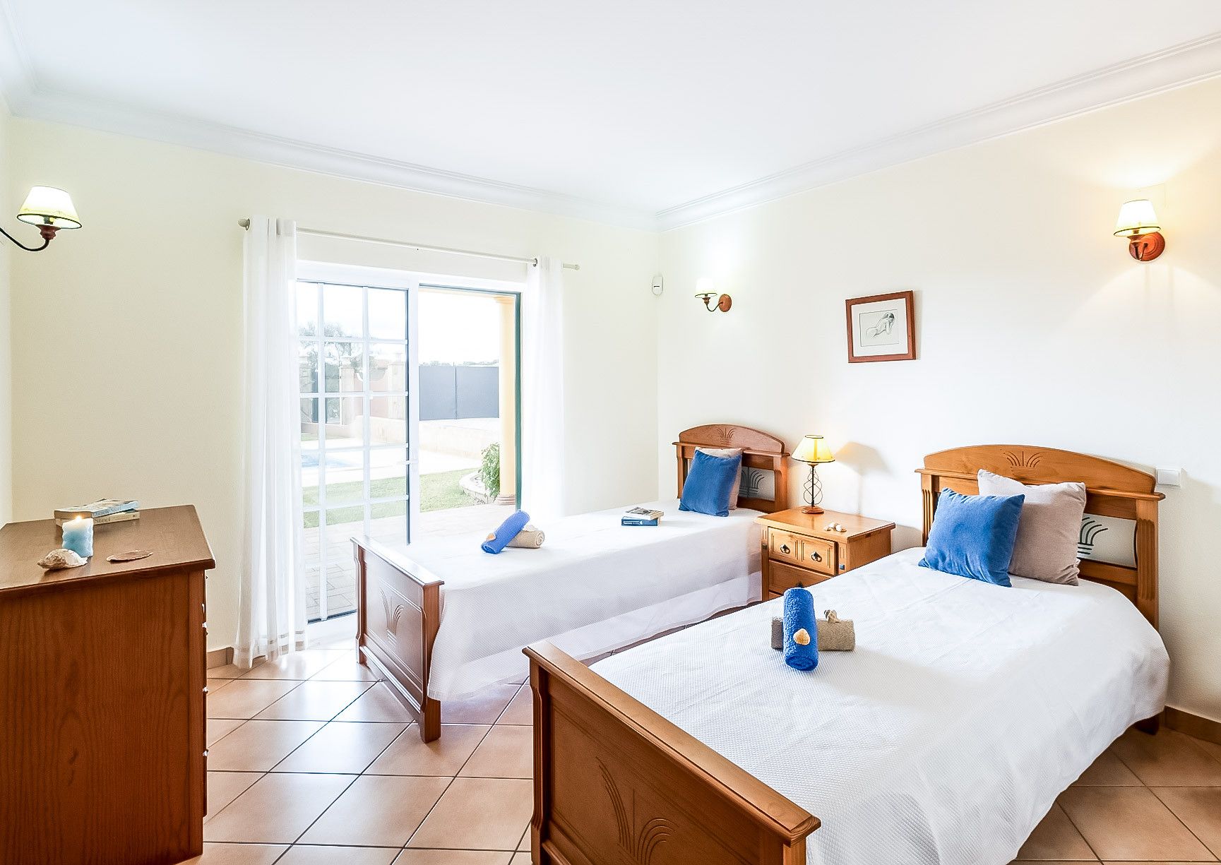 Habitación de hotel con dos camas, un escritorio y vistas al exterior.