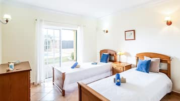 Habitación de hotel con dos camas, un escritorio y vistas al exterior.