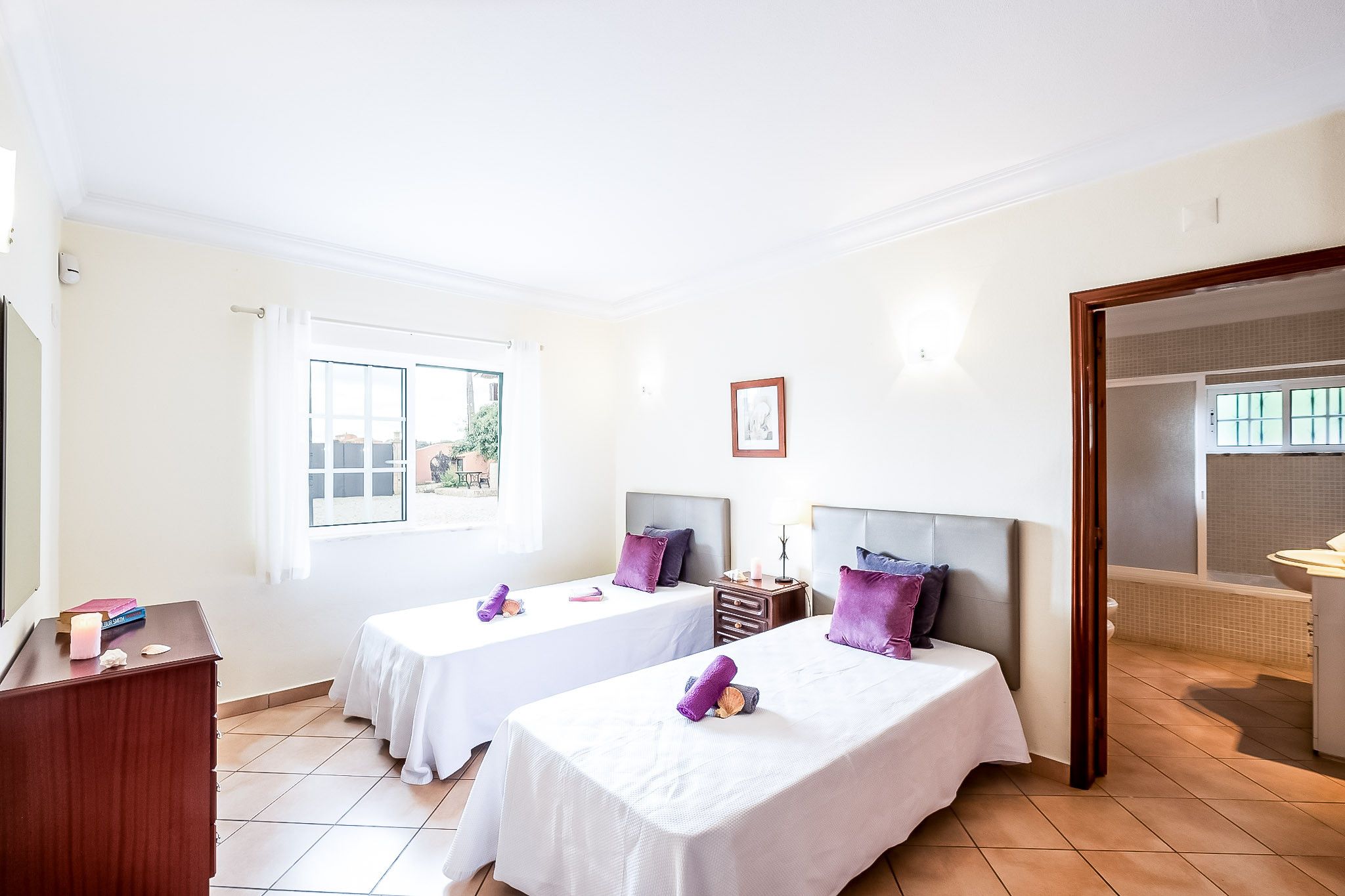 Habitación de hotel con dos camas, un escritorio, una ventana y un baño.