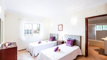 Habitación de hotel con dos camas, un escritorio, una ventana y un baño.