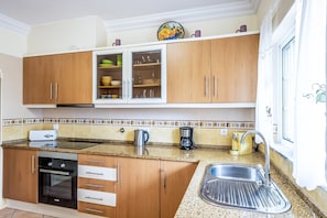 A kitchen with wooden cabinets, a stainless steel sink, a coffee maker, and a toaster. - Getaway w/ heatable pool and jacuzzi in Albufeira (Albufeira)