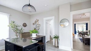 A modern kitchen with a central island, pendant lighting, and decorative wall art.