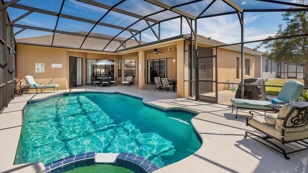 A covered outdoor swimming pool area with lounge chairs and a patio. - Bahama Sunset 5 Bedrooms (Davenport)