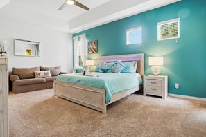 A bedroom with a bed, a nightstand, a dresser, and a window with blinds.