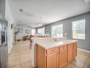 Enjoy cooking in this well-equipped kitchen with a central island, refrigerator, and dining area.