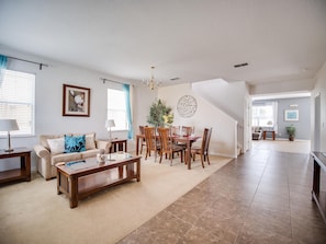 Relax in this stylish living area with a dining table, sofa, and artwork adorning the walls.