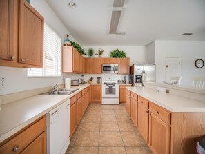 Enjoy cooking in this well-equipped kitchen with a sink, stove, microwave, and refrigerator.