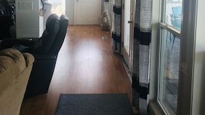 Un pasillo con un sofá, una mesa de comedor y una zona de cocina.