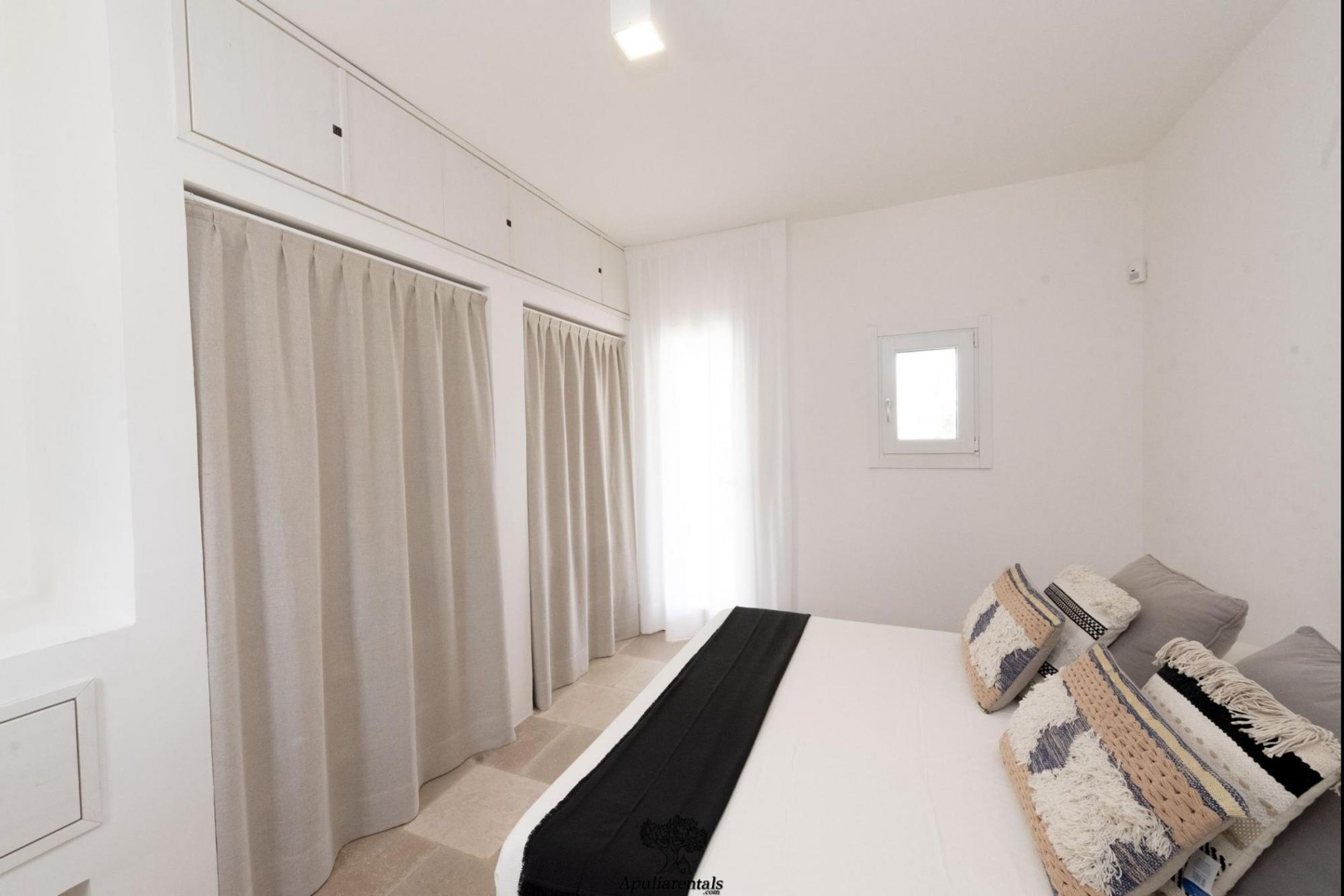 Une chambre à coucher avec un lit, une fenêtre et une armoire.