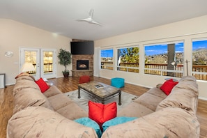 Wrap around couch in front of TV with views of patio and city of Prescott