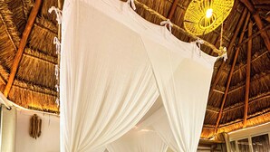 A bed with a canopy, a thatched ceiling, and a hanging light fixture. - Alito Tulum Hotel (Tulum)