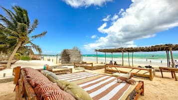 On the beach, white sand, beach cabanas, sun-loungers