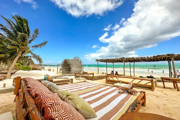 On the beach, white sand, beach cabanas, sun-loungers