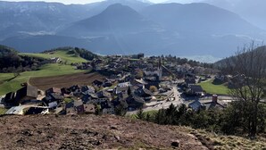 Un village avec des maisons, une église et des montagnes en arrière-plan.
