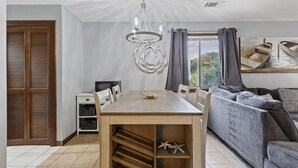 Een moderne woonkamer met een eettafel, bank en een groot raam met uitzicht op boten.
