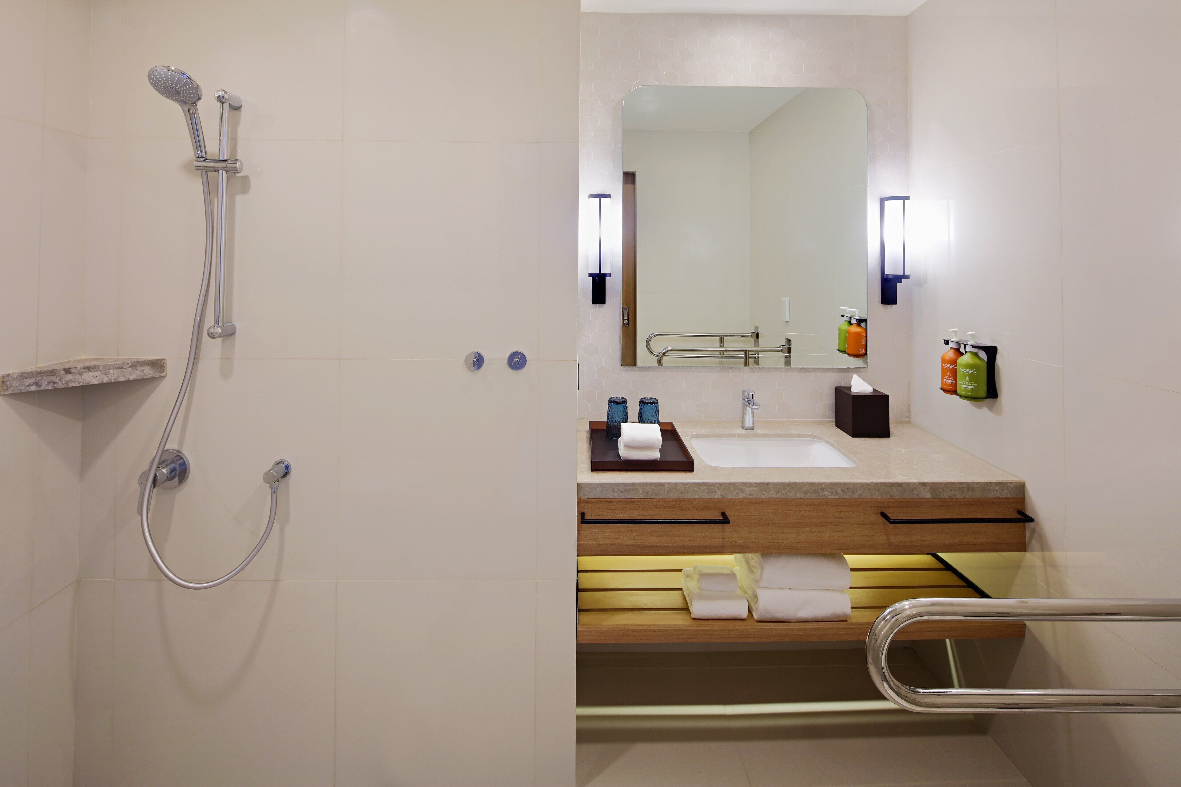 A modern bathroom with a shower, sink, and mirror.