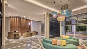 A modern lobby with a reception desk, seating area, and large windows. - Holiday Inn Cebu City by IHG (Cebu City)