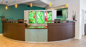Welcome to our reception area, featuring a curved reception desk and framed photographs of lush greenery.