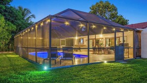 A covered outdoor area with a pool, seating, and a patio. - Family Beach Villa w/ Home Theater & Heated Pool! (Hollywood)