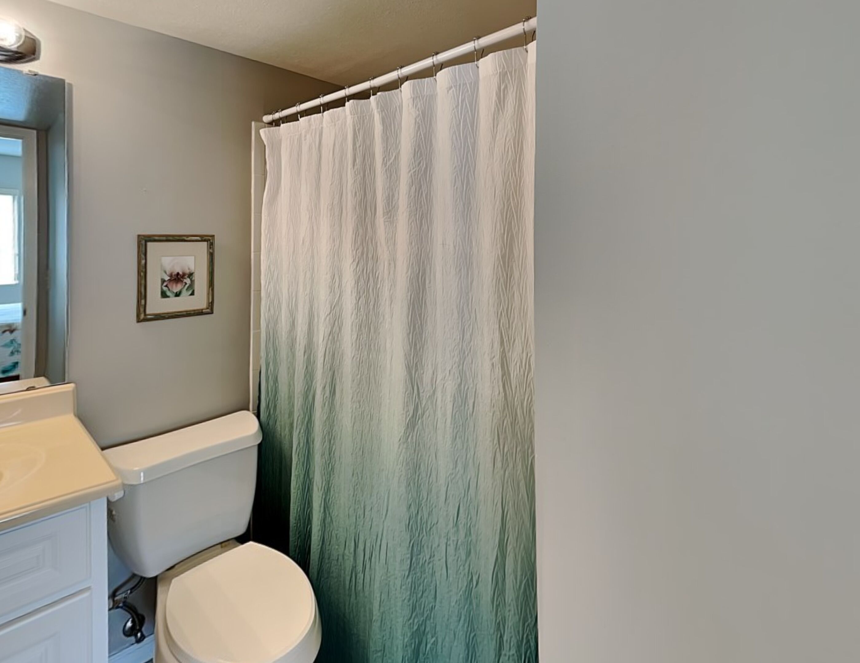 Ein Badezimmer mit Toilette, Waschbecken und einer Duschvorhang.