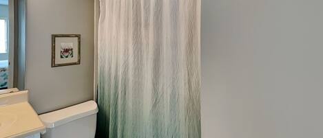 Ein Badezimmer mit Toilette, Waschbecken und einer Duschvorhang.