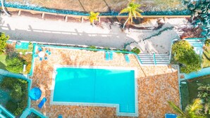 An aerial view of a resort with a swimming pool, beach, and palm trees. - Discover Your Island Oasis: St. Thomas Condo (St. Thomas)